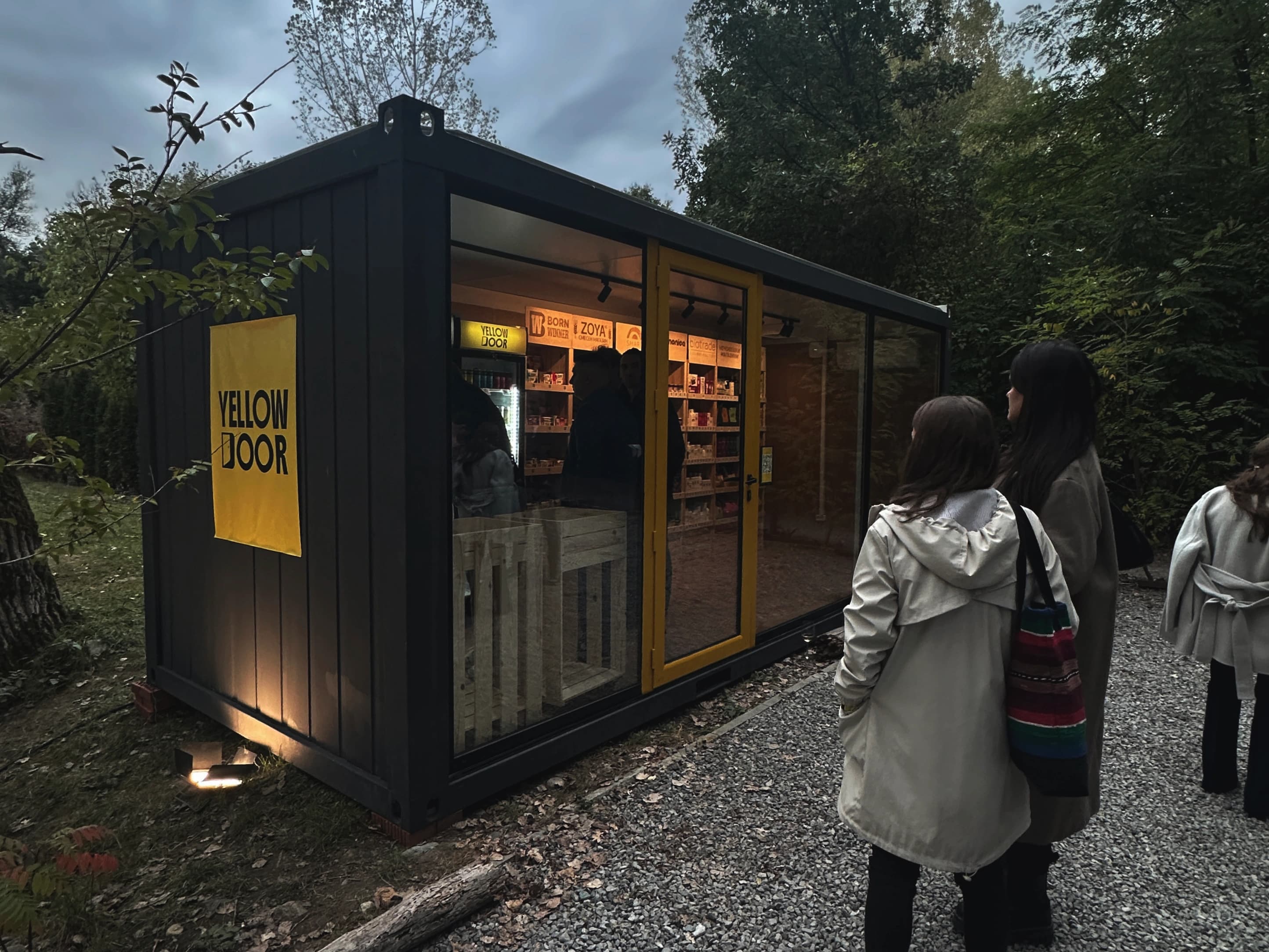 Autonomous shop Yellow Door placed outside with people in front of it